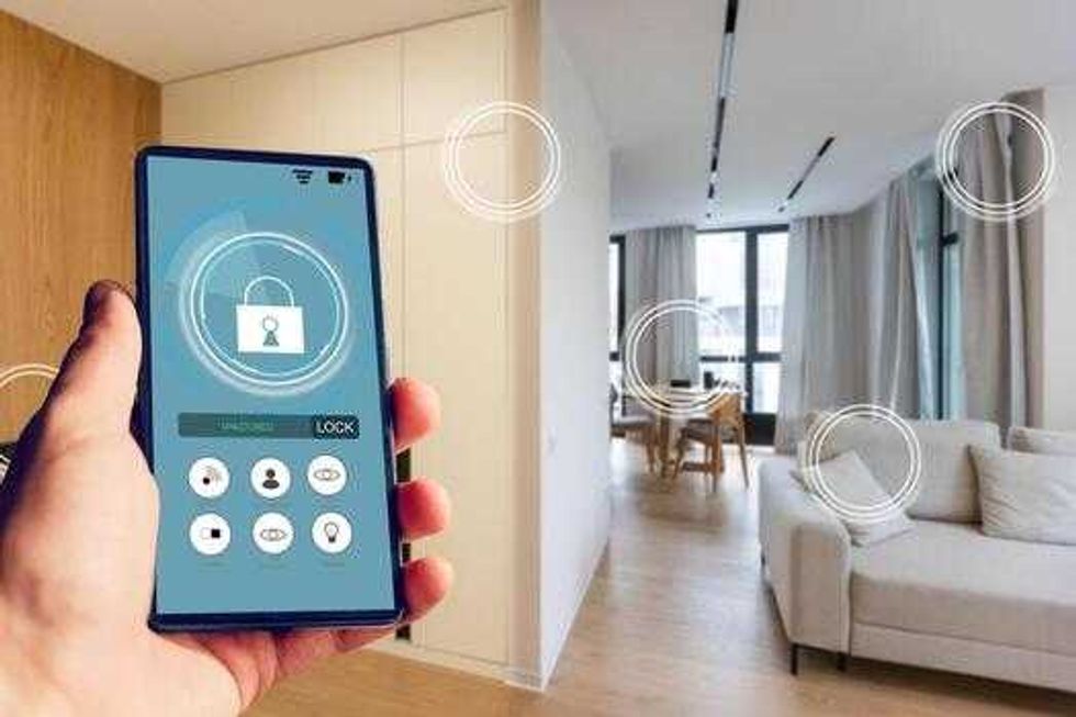 Young woman holding smart phone with launched security application at home. Concept of controlling and managing home security from a mobile device photo